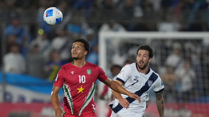 El surinamés Denzel Jubitana (izquierda) y el guatemalteco Aaron Herrera disputan el balón...