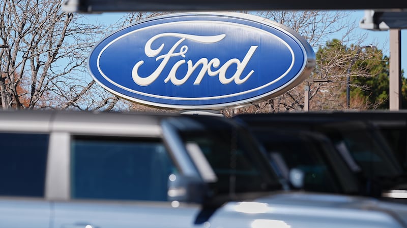 El logotipo de la empresa cuelga sobre una fila de vehículos utilitarios Bronco 2026 sin...