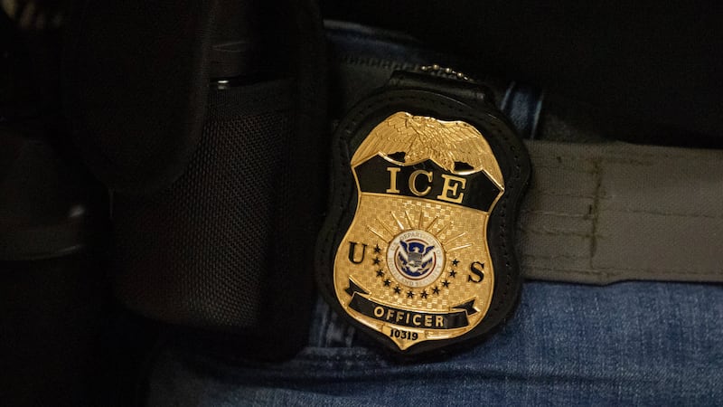 FILE - A federal agent wears an Immigration and Customs Enforcement badge in New York, June...