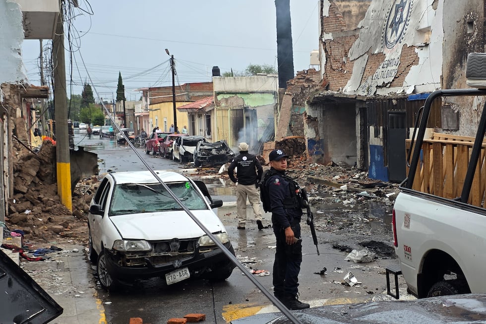 Agentes de policía se encuentran frente a una comisaría municipal dañada tras la explosión de...