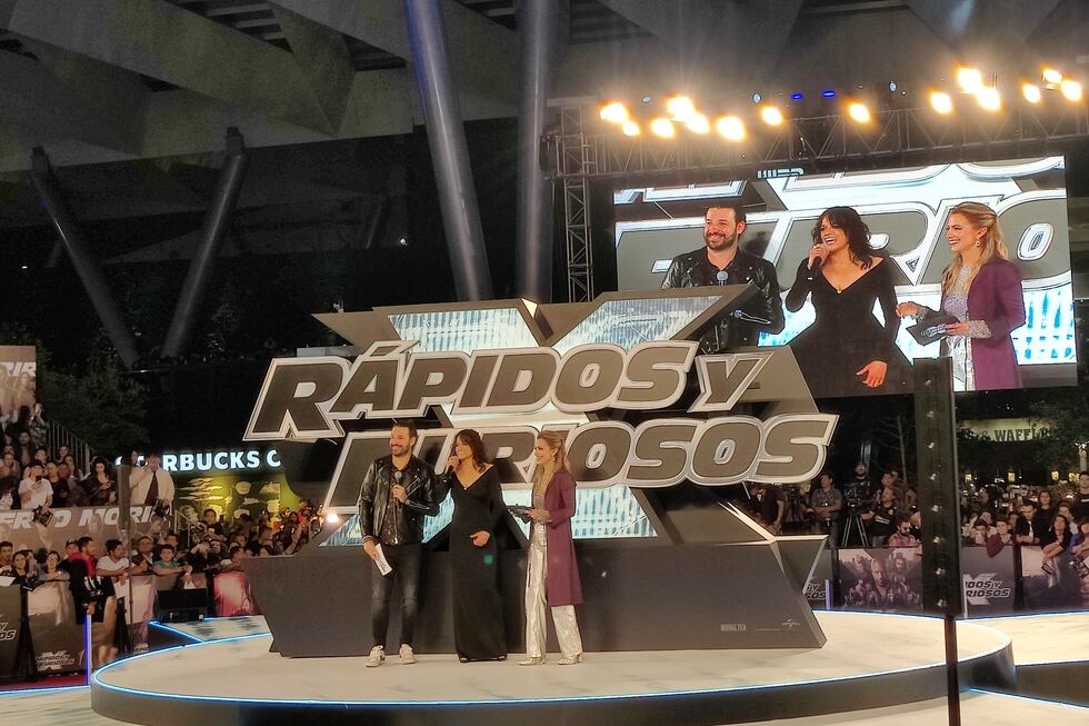 La actriz Michelle Rodríguez entre los anfitriones de la alfombra roja de la película "Fast X"...