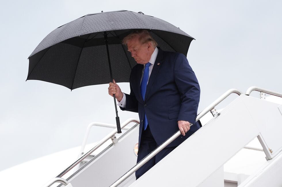 El presidente de Estados Unidos, Donald Trump, lleva un paraguas para desembarcar del Air...
