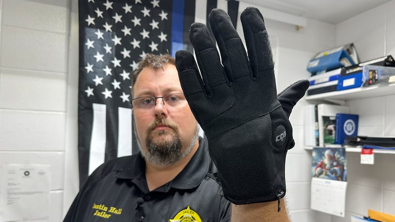 Justin Hall, custodio de la cárcel del condado de Nelson, en Kentucky, muestra un guante de...