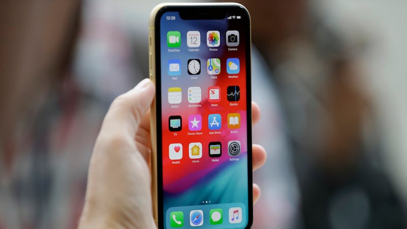 FILE - An Apple iPhone XR is held at the Steve Jobs Theater after an event to announce new...