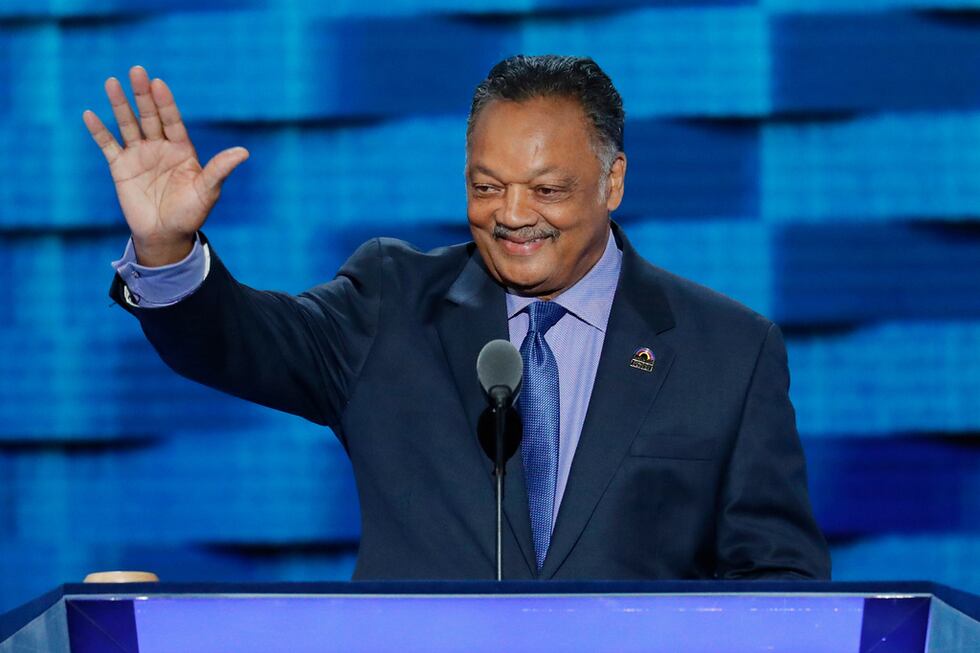 ARCHIVO - El reverendo Jesse Jackson saluda mientras sube al estrado en el tercer día de la...