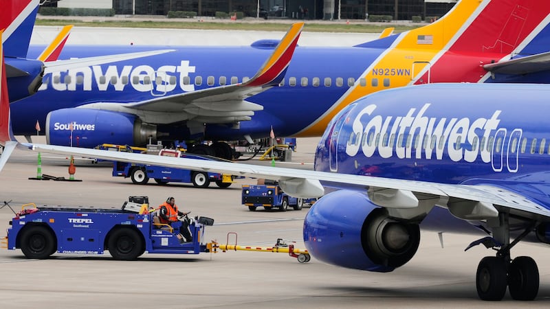 Trabajadores aéreos retiran un avión de Southwest Airlines de una puerta en el Aeropuerto Love...