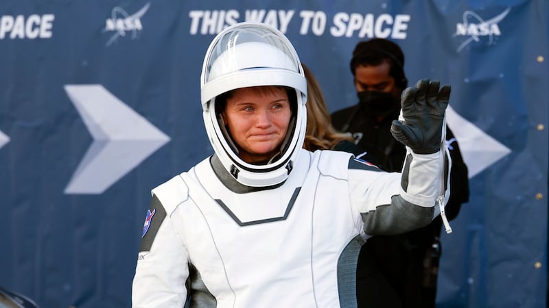Astronaut Anne McClain waves as she leaves the Operations and Checkout building before heading...