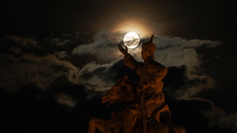 La superluna detrás de la estatua de Damdin Sujbaatar, en la Plaza Sujbaatar, de Ulán Bator,...