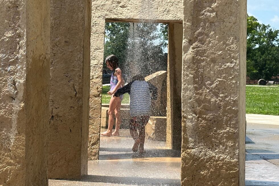 Varios niños juegan en un parque de fuentes brotantes en Des Moines, Iowa, el lunes 29 de...