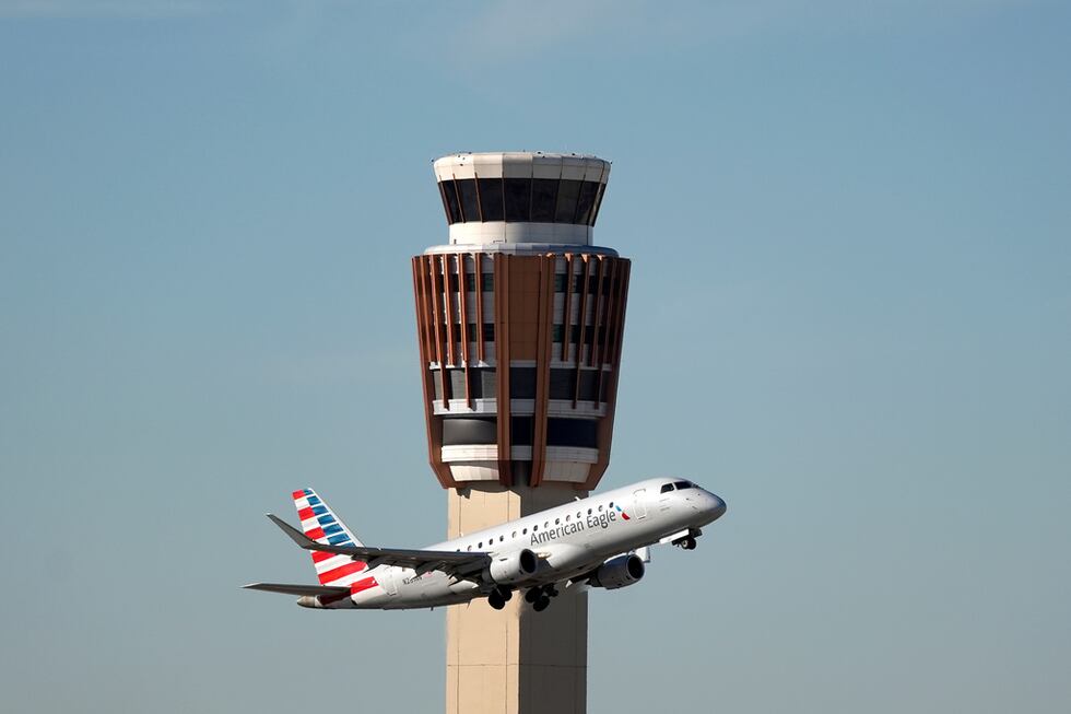 Un avión American Eagle de American Airlines pasa por la torre de control de tráfico aéreo en...