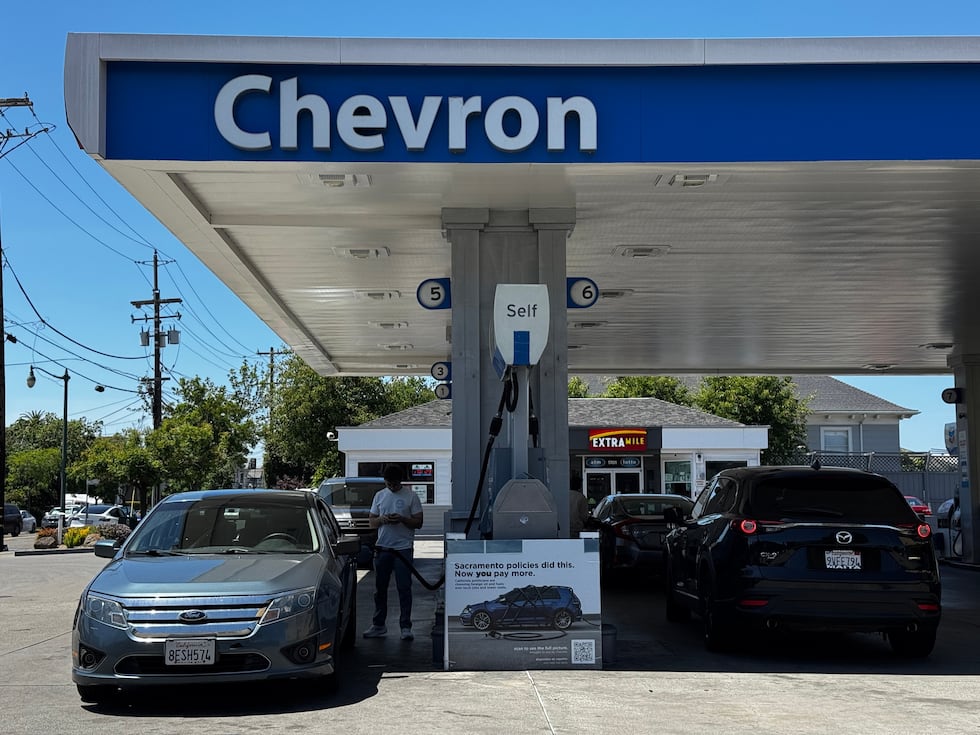 Un letrero en el que se culpa a las políticas del estado por el elevado costo de la gasolina,...
